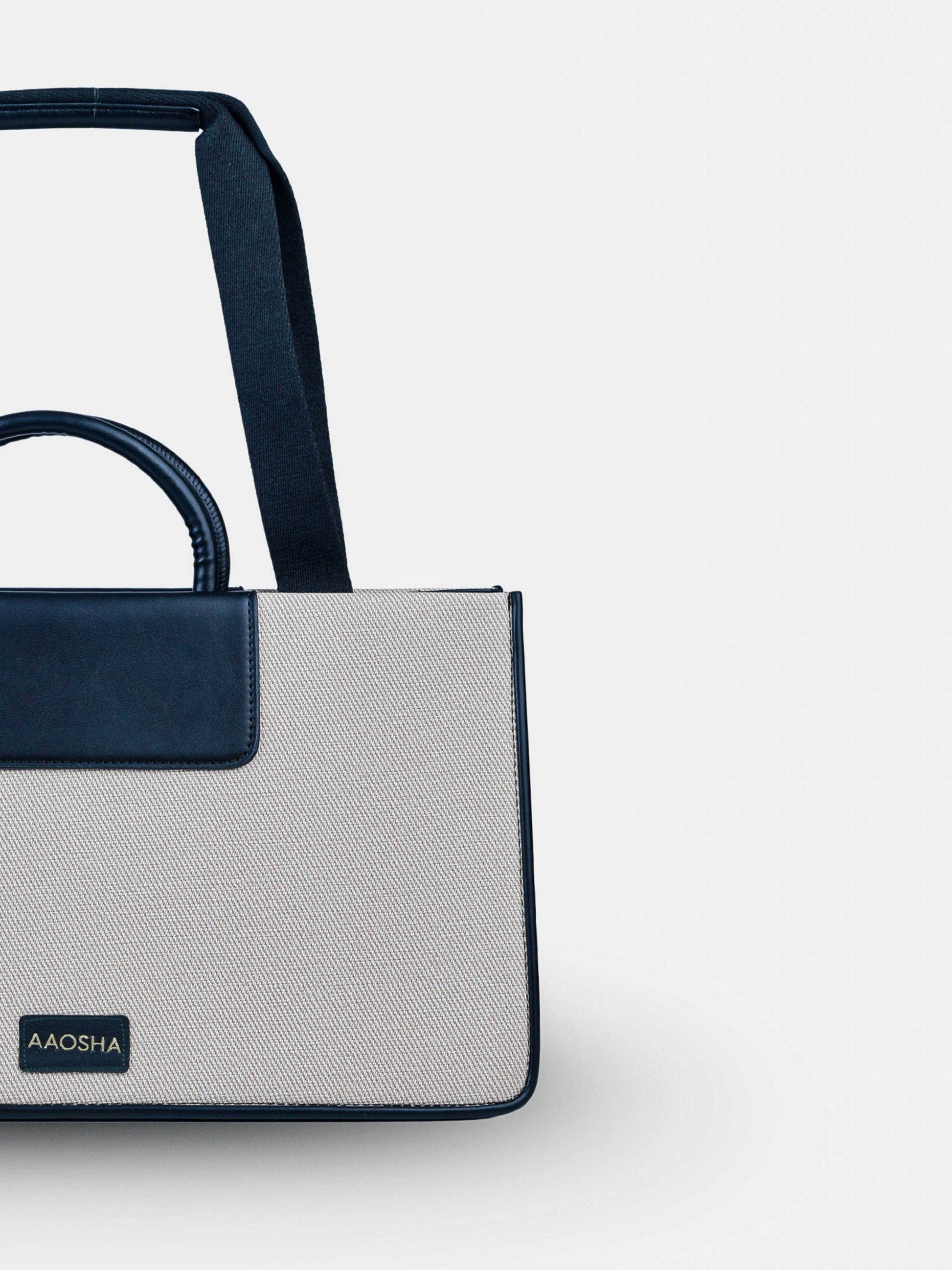 Florence Ivory Noir vegan leather tote bag in off white and black tones with structured design and dual handles for women.