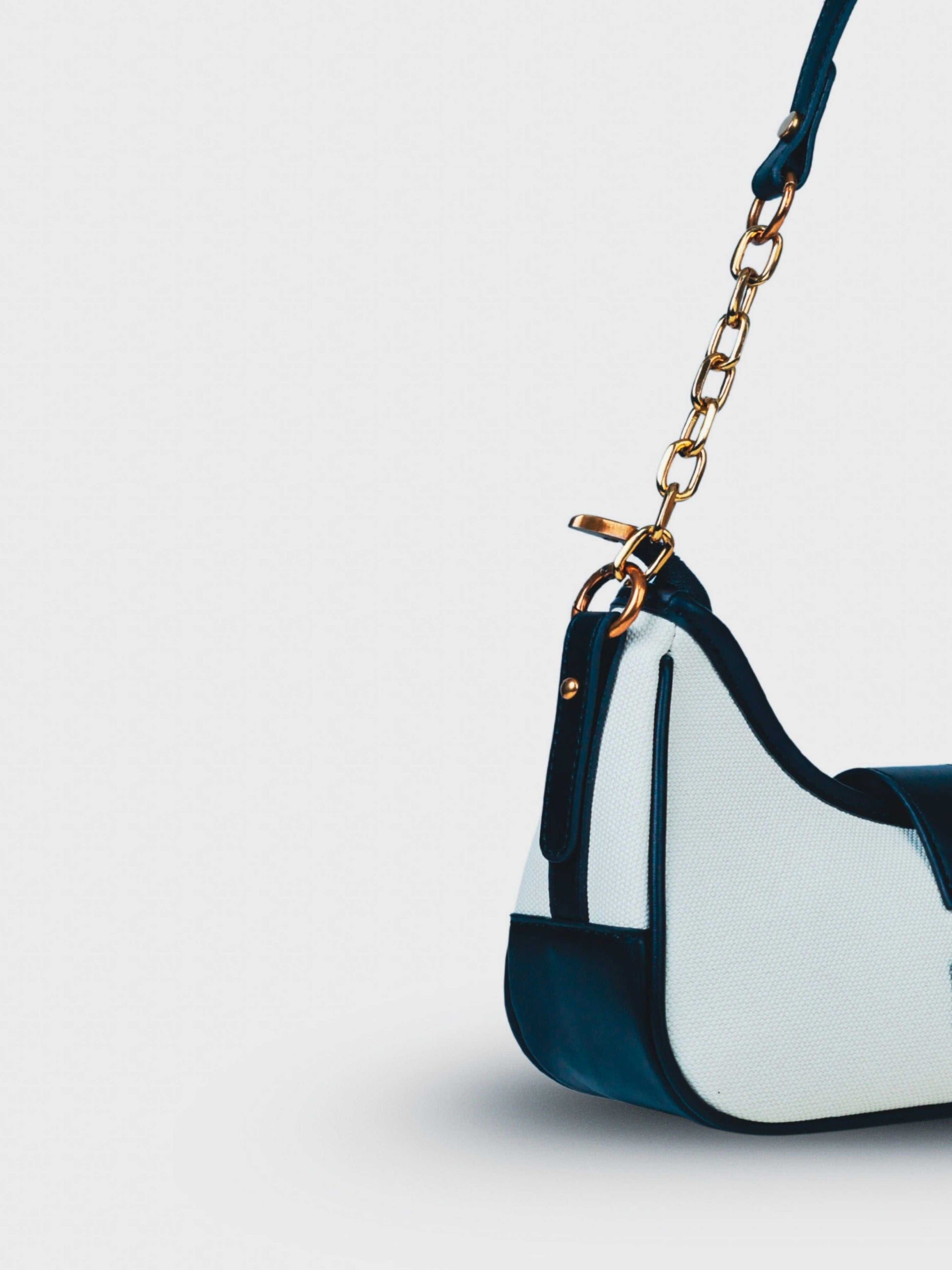 Luna Ivory Noir vegan leather shoulder bag in cream and black tones with structured design and chain handle for women.