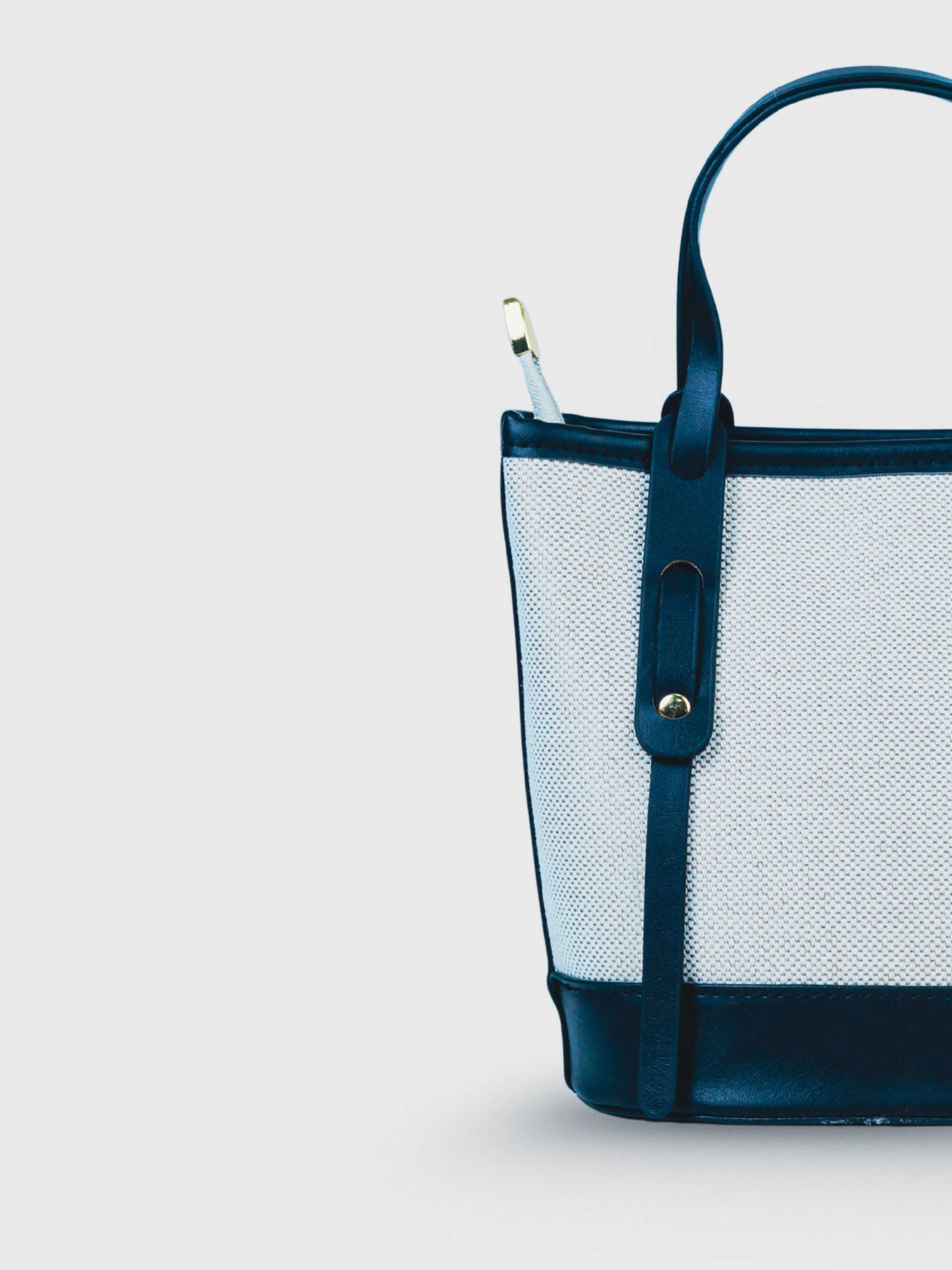 Marais Ivory Noir vegan leather crossbody bag featuring cream and black tones with structured bucket shape and adjustable strap for women.