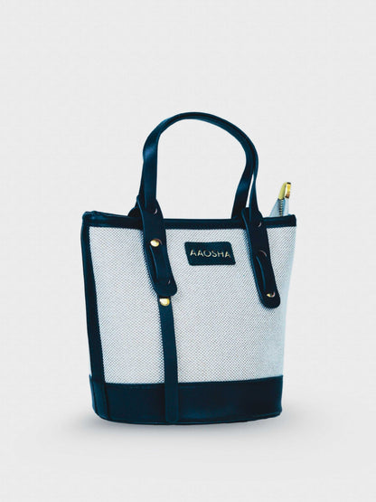 Marais Ivory Noir vegan leather crossbody bag featuring cream and black tones with structured bucket shape and adjustable strap for women.