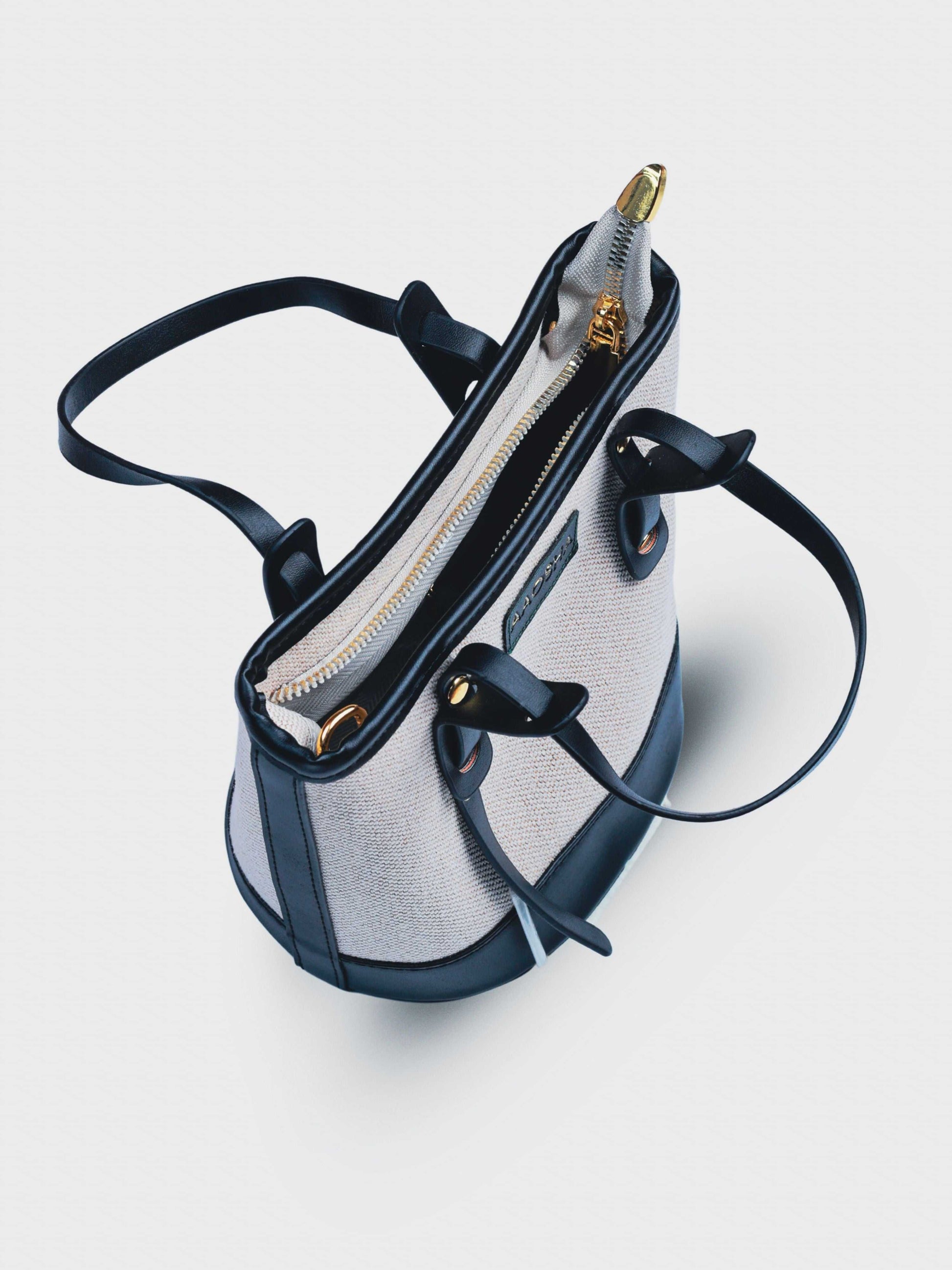 Marais Ivory Noir vegan leather crossbody bag featuring cream and black tones with structured bucket shape and adjustable strap for women.