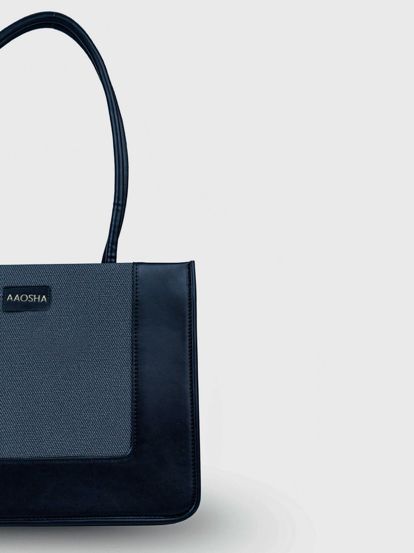 Valencia Eternal Ink vegan leather shoulder bag in pure black with structured silhouette and dual handles for women.