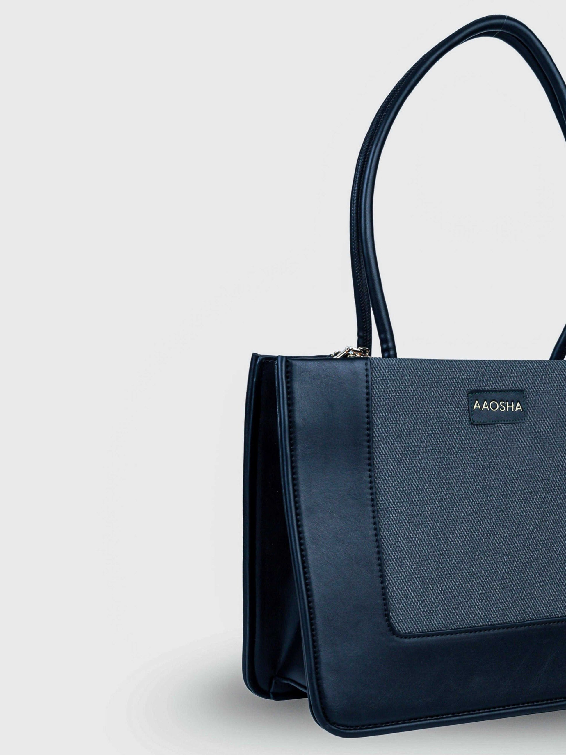 Valencia Eternal Ink vegan leather shoulder bag in pure black with structured silhouette and dual handles for women.