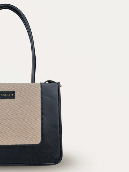 Valencia Ivory Noir vegan leather shoulder bag in cream and black tones with structured design and dual handles for women.