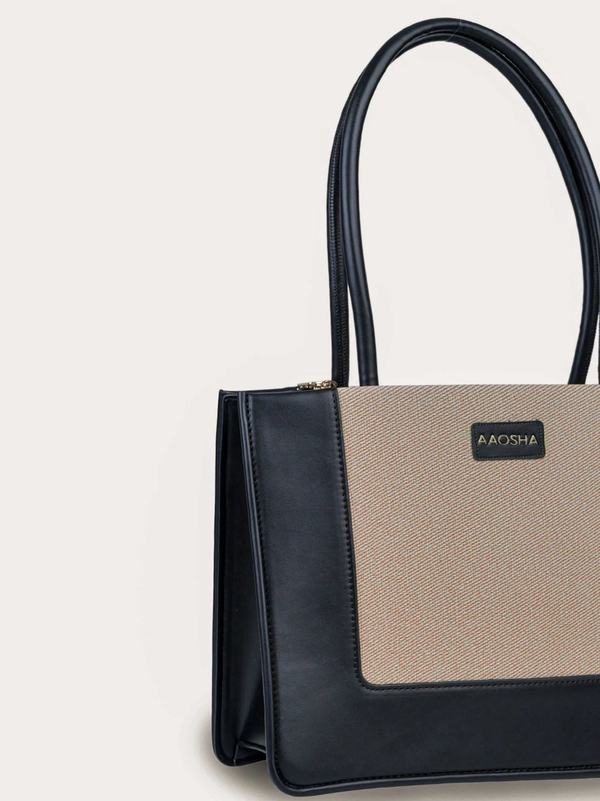 Valencia Ivory Noir vegan leather shoulder bag in cream and black tones with structured design and dual handles for women.